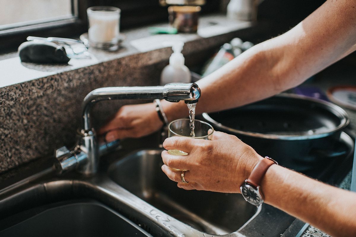 Person at a tap filling a glass of water (Getty Images/Catherine Falls Commercial)